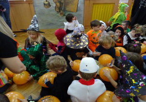 Dzieci rysują na pomarańczowych balonach.